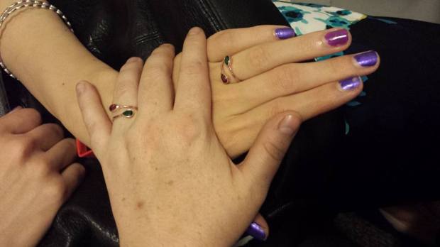 Ania's hand over my hand, both wearing our new engagement rings